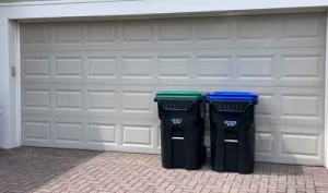 Garbage cans in front of garage.